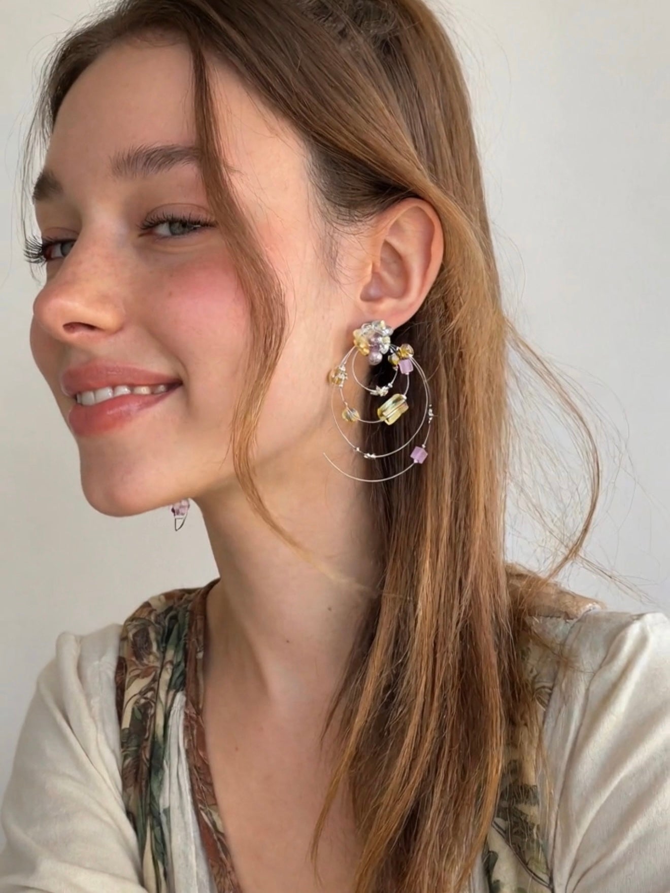 Model wearing dimensional Fullice Iris Halo earrings in soft natural light