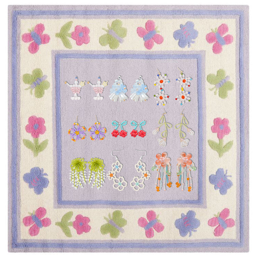 A varied collection of Fullice beaded earrings arranged by style on a floral display