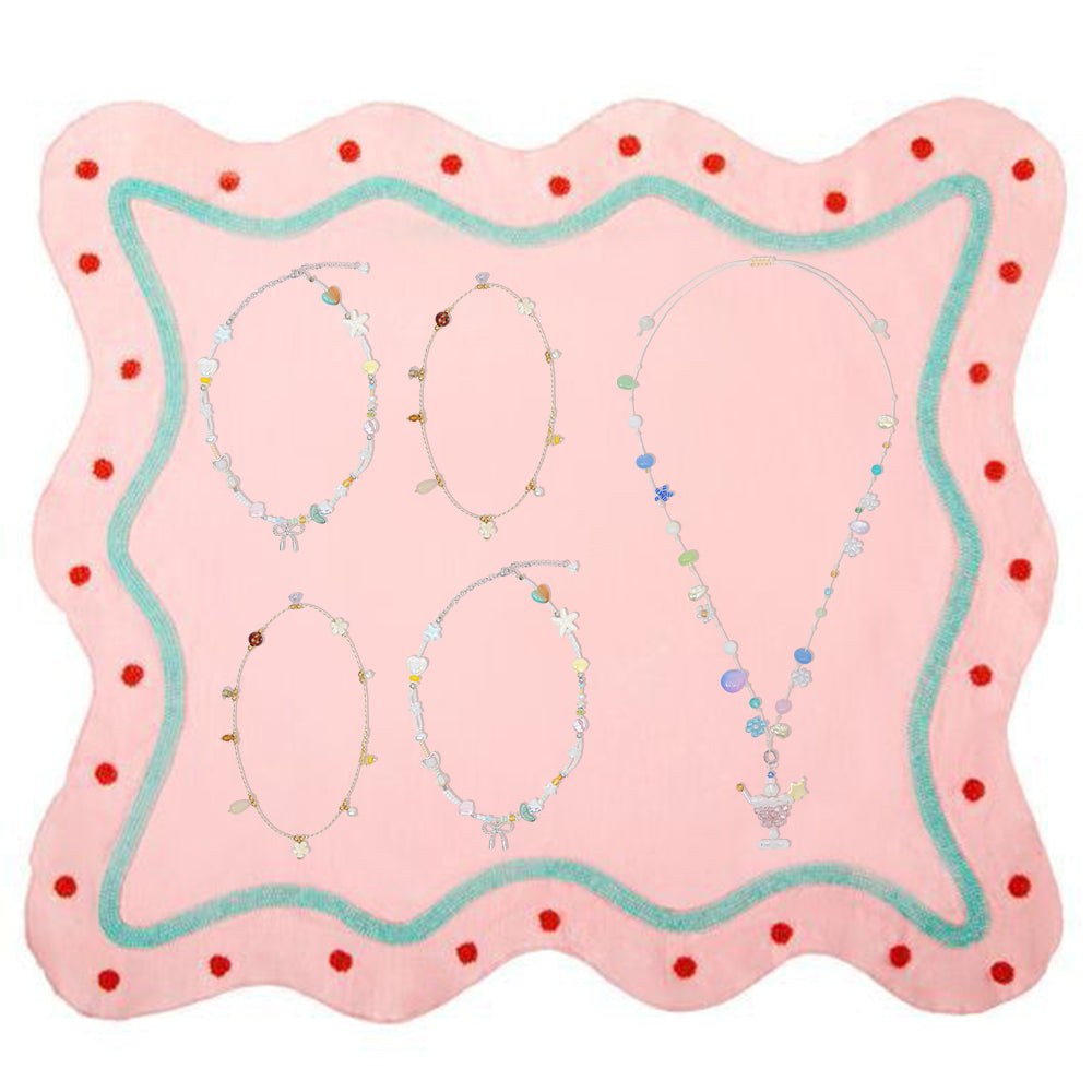 Fullice necklaces arranged separately on a pink jewelry display