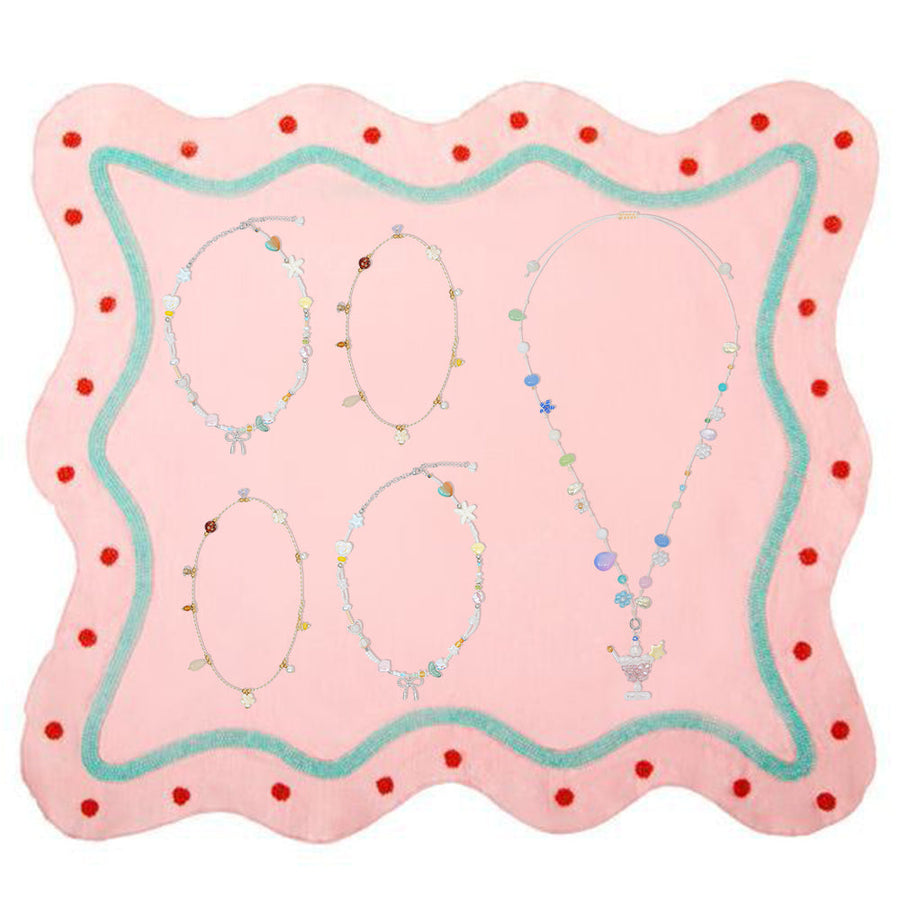 Fullice necklaces arranged separately on a pink jewelry display