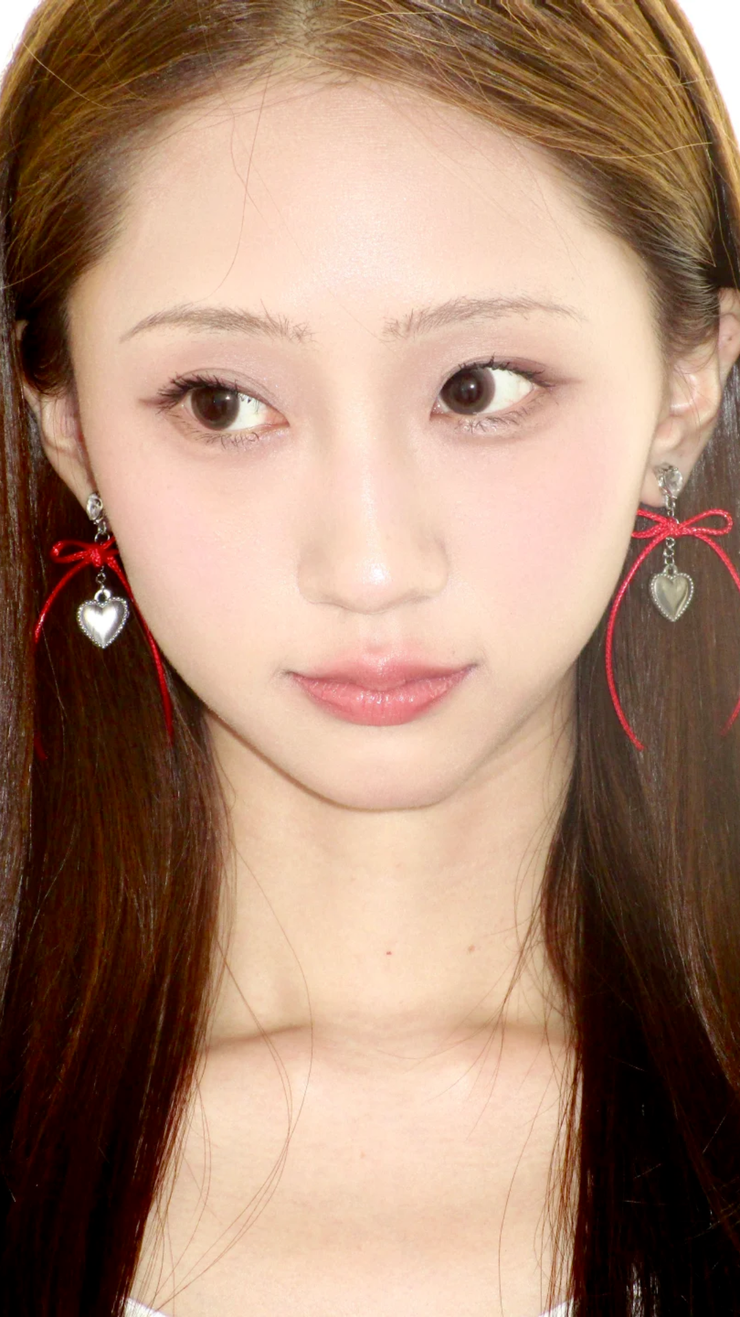 Model wearing long red Fullice bow earrings with a simple neutral outfit